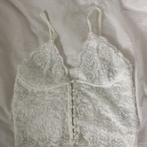  - Somrig spetstopp med supersöta pärlknappar. Står M på men skulle säga S. 