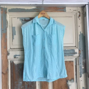  - Tunn turkos topp med vackra vita broderier. Jättefin att knyta i midjan till en magtröja. Vintage. Swish eller kontant. Kan antingen mötas upp i stockholm eller rosersberg/märsta, eller frakta. Köparen står för frakten. 