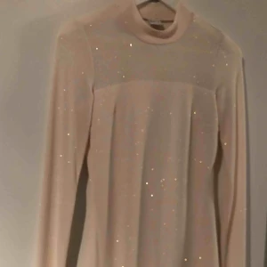  - Aldrig använd  Vit med silvrigt glitter i  Helt ok i storlek  Slutar under knäna 