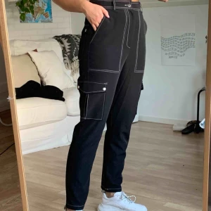  - Svarta byxor med vita kontrastsömmar. Använda endast ett par gånger. Finns att hämta i Åkersberga eller frakt 50kr :)