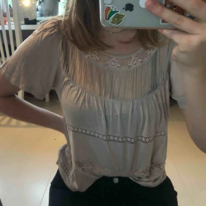  - American Eagle t-shirt blus med broderi och mesh-tyg. Beige färg, mjukt material. Fint skick! Frakt ej inkluderat.