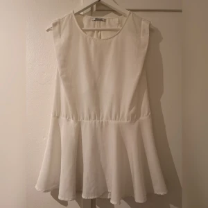  - Vit kortärmad blus med öppen rygg. Köparen står för frakt. 