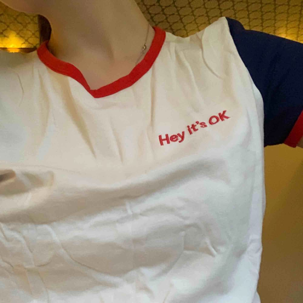 Fin t-shirt från Monki med texten ”Hey It’s OK”. Frakten är inte inräknad i priset. . T-shirts.