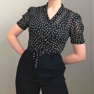  - Frakt ingår! • så fin kortärmad svartvit prickig omlottblus i ett mjukt och skirt material (100% bomull) med två fickor framtill från Cacharel • i storlek 36, mycket fint skick!