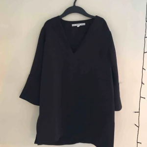  - Marinblå blus, lite längre modell med slits på sidorna. Frakt tillkommer.