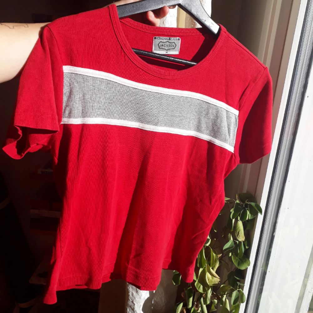Vintage röd t-shirt med en grå horisontell rand på. Randen är något sne men det ger den lite karaktär.😉. T-shirts.