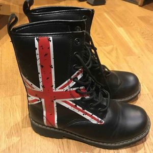 Kängor  - Nya kängor med flaggtryck. Aldrig använda. Snörning och kraftiga sulor i stl. 38. Finns i Nacka. Köpare står för porto 