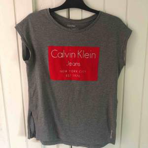 Grå Calvin Klein t-shirt. Använd fåtal gånger. En ”slits” på vardera sida Nypris 500 :-