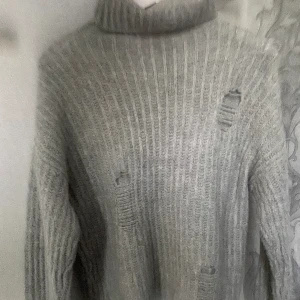 Kappahl, stickad polotröja.storlek s/m - Grå stickad polo tröja, köpt för två pr sen i Kappahl. Köpt med slitningar som detaljer både bak och fram. Annars aldrig använt så den e helt ny!