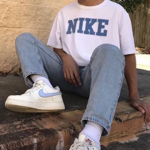 Vit t-Shirt med blått Nike tryck - Tröjan är i bra skick, förutom en liten slitning på trycket (syns inte på om man inte står nära). Tröjan klarar endast handtvätt. Säljer vidare eftersom den inte passade mig.          Står ej för frakt!