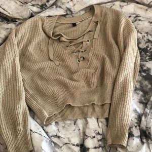 Beige stickad tröja - jättefin stickad tröja med snörning, använd ett antal gånger men i fint skick✨ fraktkostnad tillkommer 