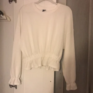 Vit blus  - Helt ny, volanger vid magen och armarna storlek L men passar också väldigt bra om man har storlek M 