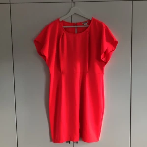Klänning Neon - Neonrosa/-röd klänning i strl. L. Smått öppen i ryggen. Extra knapp finns.
