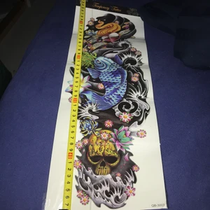 Temporär tatuering - Säljer den här temporära tatueringen då jag inte fått användning av den, helt oöppnad! Jättefina detaljer och med en blå ’koi’ fisk. Som man kan se på bilden är tatueringen ungefär 47 cm lång, ca 15 cm bred. Frakt på 24 kr!