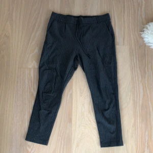 Kostymbyxor Mörkgrå - Mörkgrå kostymbyxor med mm-tunna vita streck. W=XL, L=34