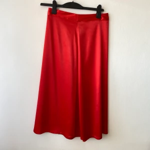 Satin Midi Skirt - Satin Midi Skirt i rött från Nakd. Sparsamt använd så i fint skick, bara ngra trådar som går på baksidan (se bild nr tre). Säljer då det inte är min stil längre. Nypris 399kr, säljer för 100kr plus 63kr frakt (spårbart via Postnord) 🌟