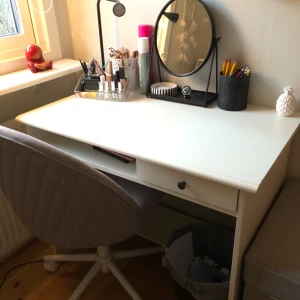Skrivbord - Hejsan! Säljer nu mitt skrivbord pga. att jag fått ett nytt. Det är i fint skick och fungerar även bra att använda som ett alternativt sminkbord. Bordet har en liten låda, ett ”hål” som fungerar bra för förvaring samt ett fotställ (som jag själv använt att ställa mindre förvaringslådor på).  Måtten är: Långsida=90 cm, Kortsida=54 cm och höjden= 74 cm.  Säljer för 150kr och hämtas i Sollentuna.☺️☺️