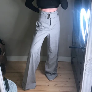 Byxor Mango - Grå byxa från MNG Suit. Älskar dessa men säljer då de tyvärr inte passar mig längre. Hög(!) midja, wide leg med inbyggt skärp. Skulle säga att de passar storlek 38-42. Lång model så passar bäst om du är längre alt. med ett par klackar. Kan även posta, pris ex. frakt 🌸