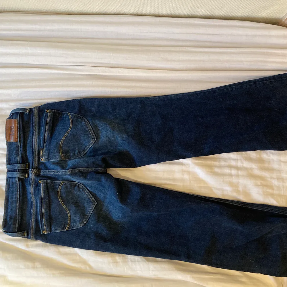 Mörkblå lowwaisted Lee-jeans med snygga bakfickor. . Jeans & Byxor.