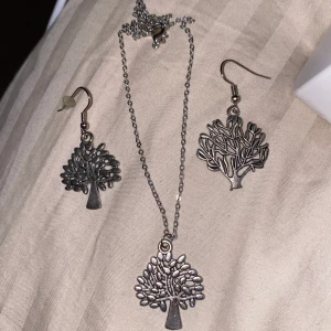 Halsband o h örhäng set  - Jätte gulligt halsband samt örhäng ser med ett träd på halsbandet och ett likadant träd på ena örhänget och ett höst träd vid andra örat. Silver färgad aldrig använd.