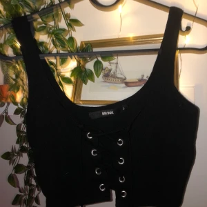Crop top med snören  - Svart crop top från bik bok som går att snöra ihop men också snöras ut🥰