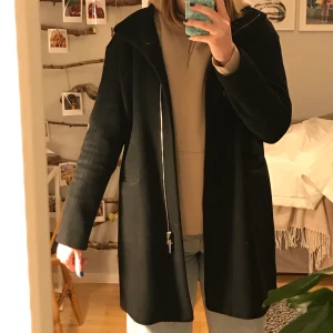Svart kappa - En svart kappa med dragkedja. Kappan är storlek 42 men jag är vanligtvis en m och ni kan se hur den sitter på mig på bilderna. Frakt ingår inte