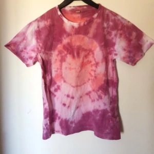  - en  lila / orange / rosa batik-T-shirt 
Lappen säger strl M men skulle säga att det är en S
