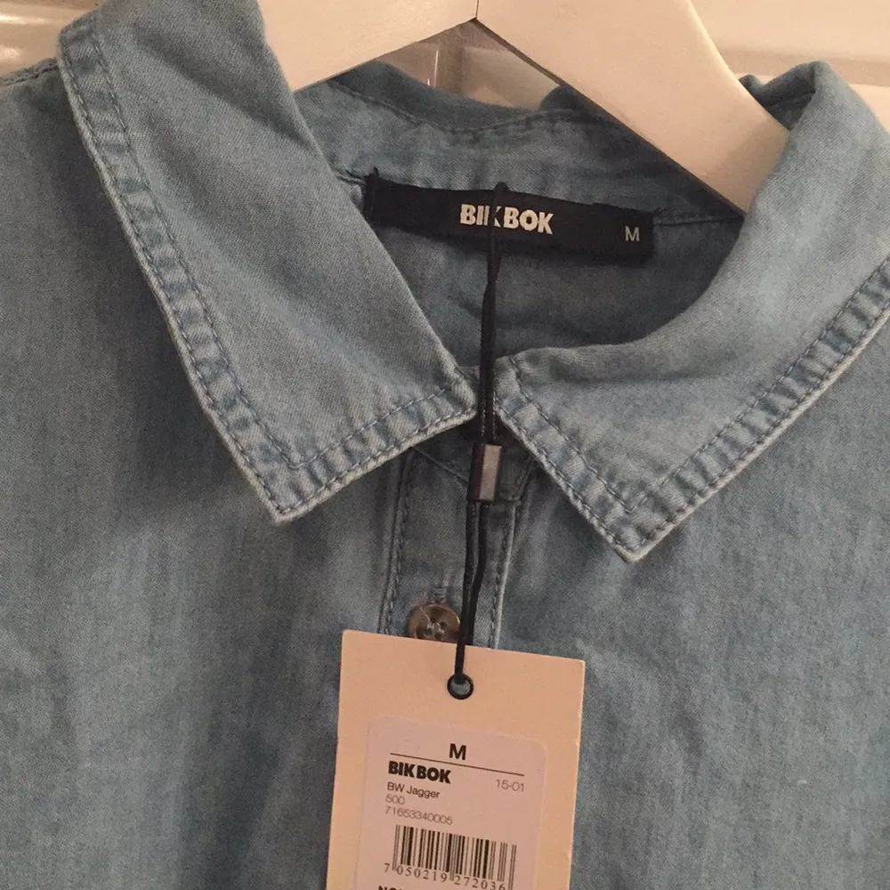Jag säljer min ljusblåa jeansskjorta ifrån BikBok i storlek M då den aldrig blivit använd, lapparna sitter till och med kvar. Jag tycker den är storleksenlig!. Skjortor.