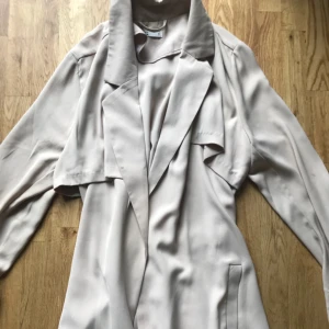  - En lång beige kappa från Cubus i Stl S Ej frakt. Hämtas i Hornstull.  