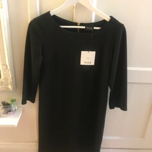 - Helt ny, lapp kvar.  Svart basic klänning med halvlång arm & dragkedja i ryggen. 