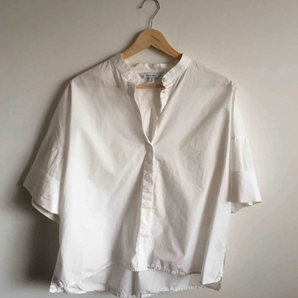 Vit croppad skjorta i krispig bomull. Använt skick, liten fläck på höger bröst (bild 3) i övrigt okej. Priset inkluderar frakt!. Blusar.