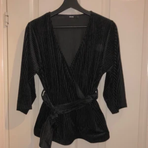  - Svart topp med bälte i midjan. I väldigt gott skick, köpare betalar frakt.