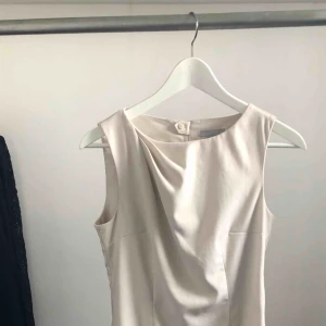 - Stilren, figursydd klänning i grå/beige som slutar precis ovanför knät. Underbar modell men säljer pga jag äger för många liknande. Köparen står för frakten.