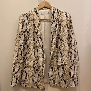 Nelly Oversized ormkinns blazer/kavaj  - Fin oversized blazer/kavaj från Nelly i ormskinnsmönster! Har aldrig använts och säljes pga inte riktigt min stil, men supersnygg ändå! Originalpris 499, storlek 34 men passar även 36. Kan mötas upp i Stockholm, annars ingår frakt ej. Skriv vid frågor!🥰