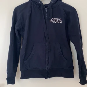 Svea kofta  - En mörkblå kofta från Svea. Tryck på luvan. I bra skick. Fraktkostnad tillkommer.