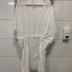 Strandplagg Panos Emporio - Vit väldigt fin strandklänning/strandplagg från Panos Emporio. Lätt att ta på sig över bikinin ner till poolen elr ha på stranden.