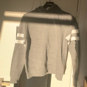 Grå hoodie  - Grå hoodie med vita detaljer, nästintill oanvänd från Gina tricot. Mysigt och varmt material i tröjan. Storlek M