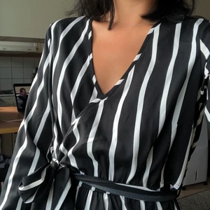 Klänning fr. Boohoo strl 36 - Oanvänd!! Skön tunn klänning i siden-liknande material från Boohoo. Storlek 40 enligt hemsidan men sitter som en 36 enligt mig! V-ring med knyte i midjan, långa armar. Jag står för frakten på detta plagg :) 