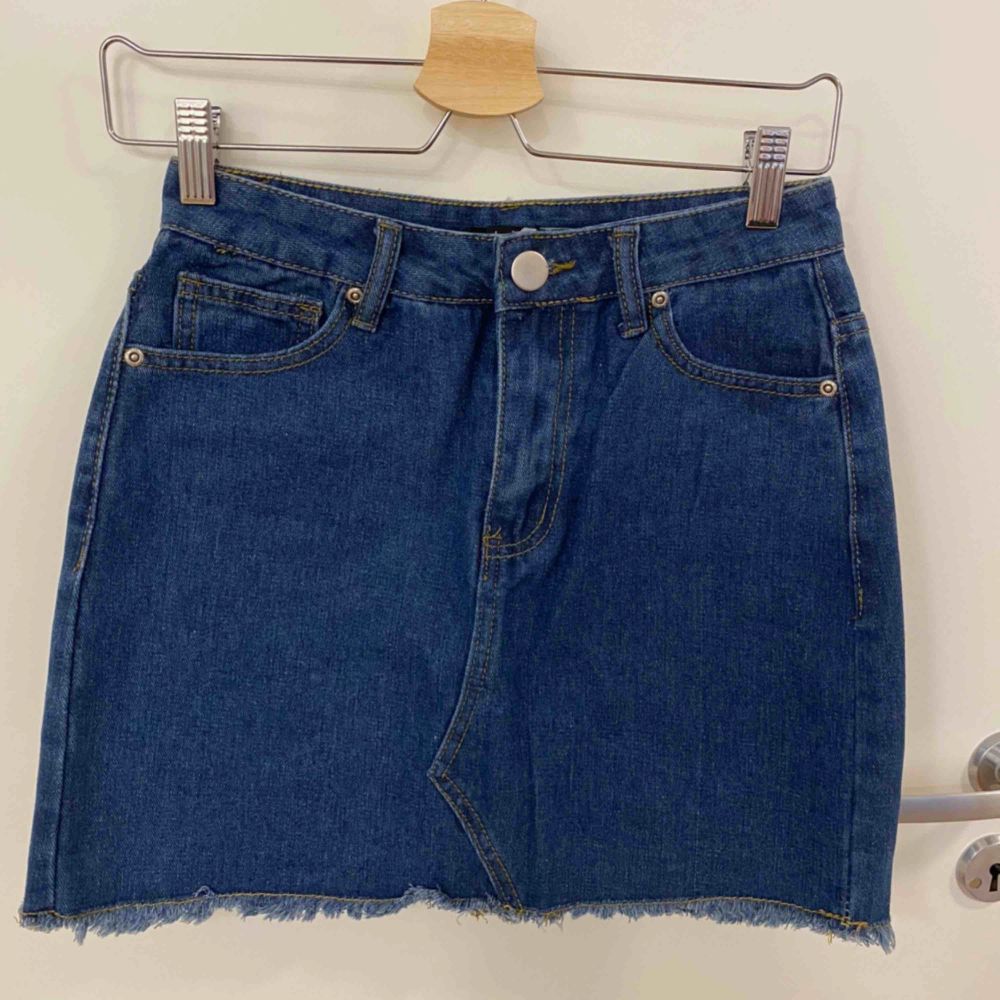 Jeans kjol med hällor upptill, fickor både fram och bak, fransar längst ner samt knapp o dragkedja som öppning. Aldrig använd . Kjolar.