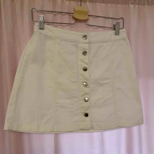 Vit kjol - Vit jeans kjol med knappar som öppning. Aldrig använd
