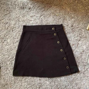  - Superfin svart kjol med fina detaljer framtill, frakt är inkluderat i priset!