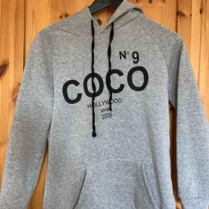  - Grå huvtröja, bra skick nästan oanvänd. Mysig innuti. Chanel inspirerad tröja.  Köparen står för frakten.