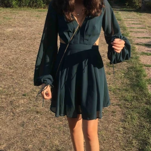  - superfin mörkgrön klänning från asos! endast använd vid ett tillfälle. öppen rygg (se sista bilden) och fina puffärmar. storlek 32 (xxs-xs), jag på bilden är 158 cm lång. 100% polyester. nypris var drygt 500 kr + frakt. spårbar frakt ingår i priset!💞