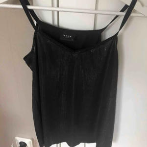  - Ett glittrigt svart linne från vila. Fin att ha till fest. Linnet är i ett bra skick. Kan mötas upp i Uppsala eller frakta linnet. 