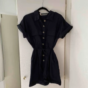  - Svart Oversized jumpsuit från Nelly. Använd ett fåtal gånger. Storlek 34 men skulle absolut passa 36-38 också utan problem så den har ett band man drar åt i midjan. Vid frakt står köparen för fraktkostnaden.