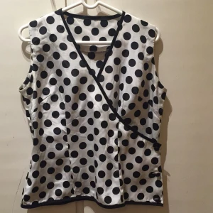  - Sött, prickigt omlottlinne, handsytt. Inte mycket använt. Materialet är något glansigt sidenliknande tyg. 