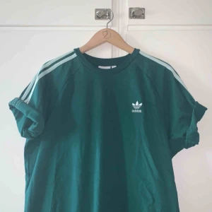  - (Äkta) Adidastisha i mossgrönt. Färgen återgavs inte så rättvist på mina bilder, så sista är lånad från Zalando. Passar XS-M beroende på hur man vill att den ska sitta. I nyskick. Möts upp i Stockholm, annars står köparen för frakt :) 