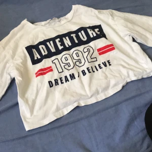 T-shirt - En kortärmad magtröja med ett rött och blått tryck. Bra skick, inga hål eller fläckar. Frakt 15kr