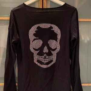 Zadig & Voltaire tröja - Svart långärmad tröja med döskalle tryck på baksidan. Tunt material, super skön på! Lite u ringad fram. 