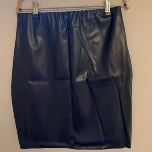 Svart skinnkjol i Small - Säljer denna svarta skinnkjolen från boohoo i storlek S, resorband i midjan och går till mitten av låren.